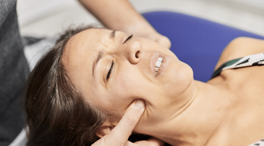 Anonymous therapist pressing cheeks of patient