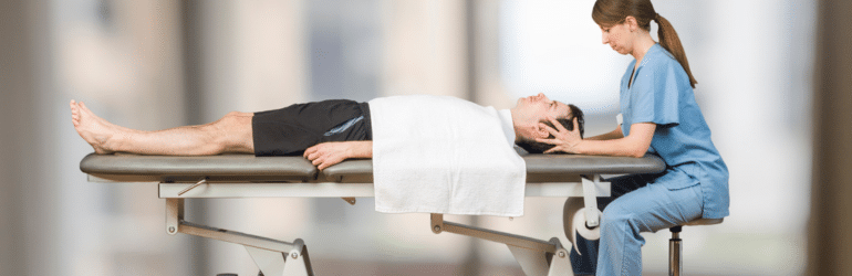 Physiotherapist is doing craniosacral therapy in a stretcher over white background